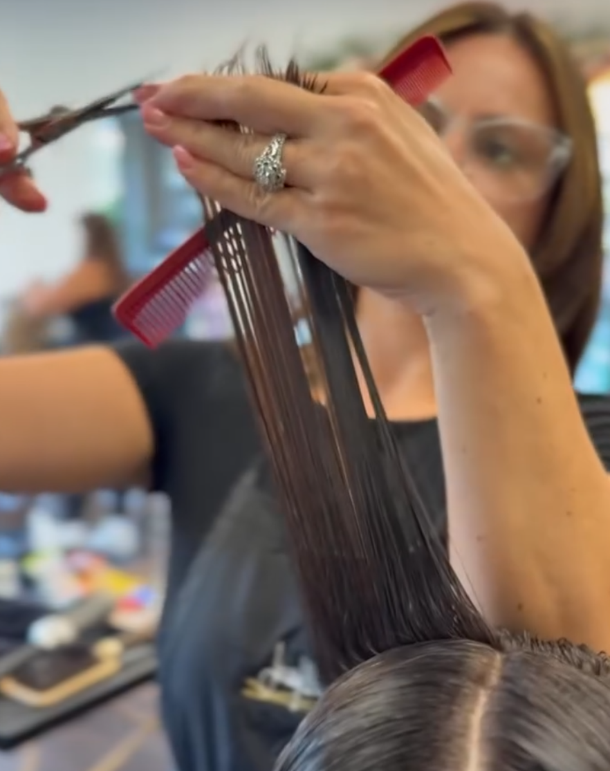 Stylist cutting hair.